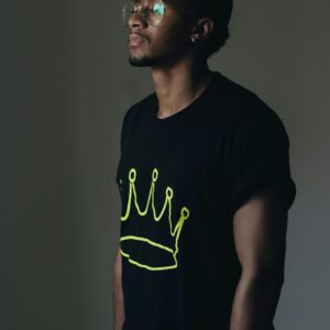 African man posing in casual wear indoors, conveying a relaxed style.