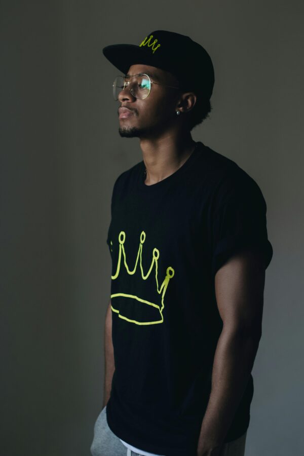 African man posing in casual wear indoors, conveying a relaxed style.